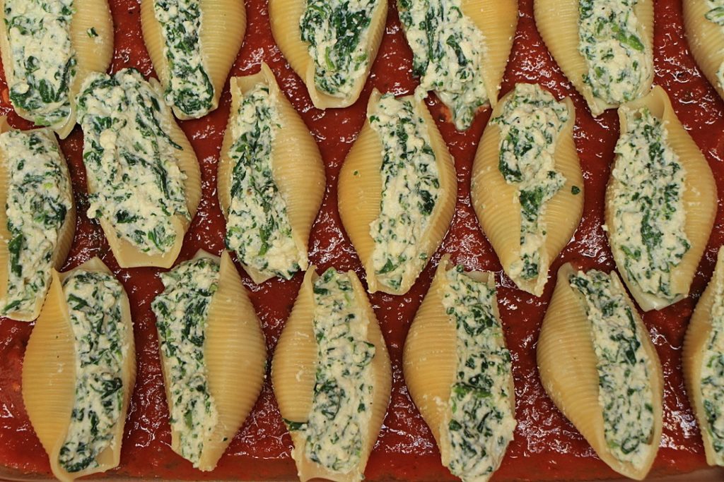 Filled shells on top of sauce