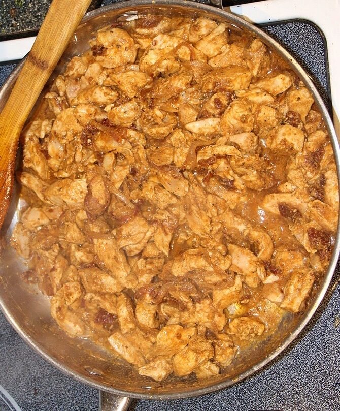 Chicken, spices and water in a pan for pulled chicken